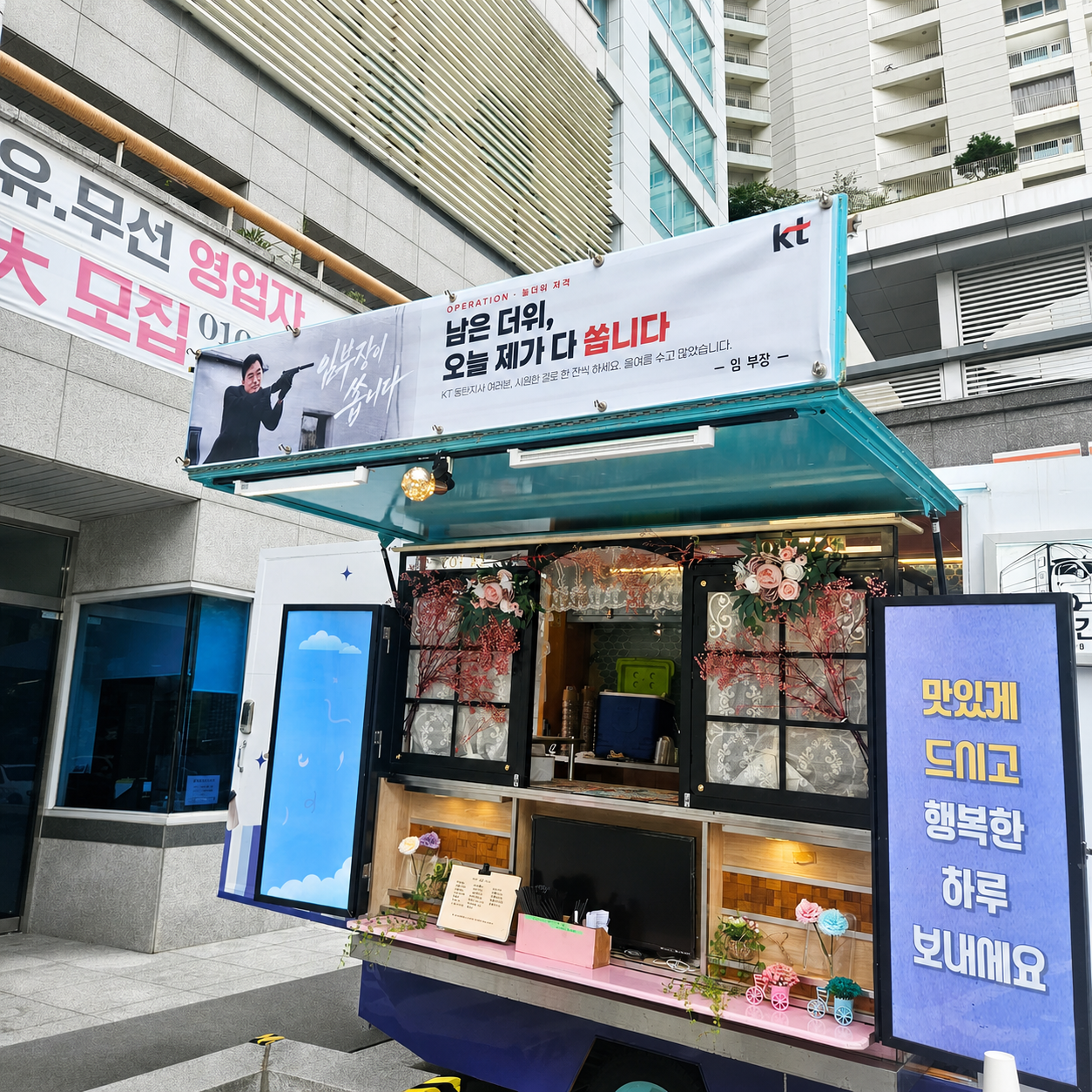 KT 동탄지사 사옥 앞에 세팅된 승진 축하 푸드트럭과 상단 응원 현수막